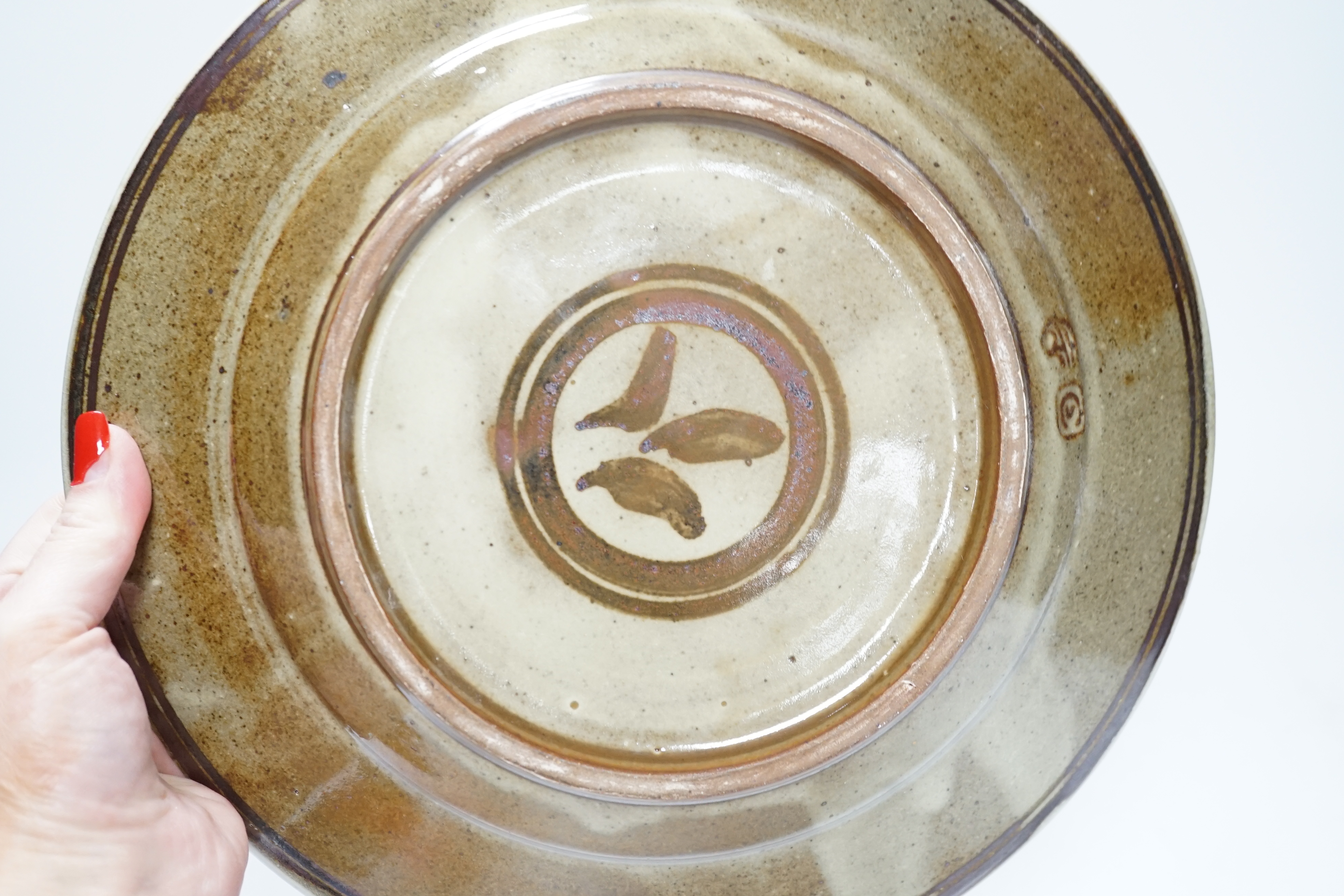 A Seth Cardew studio pottery stoneware dish, decorated with a bird and stylised flowers, 28cm in diameter